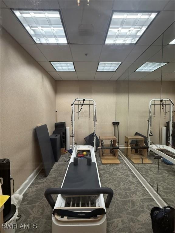 exercise area with a drop ceiling and dark carpet