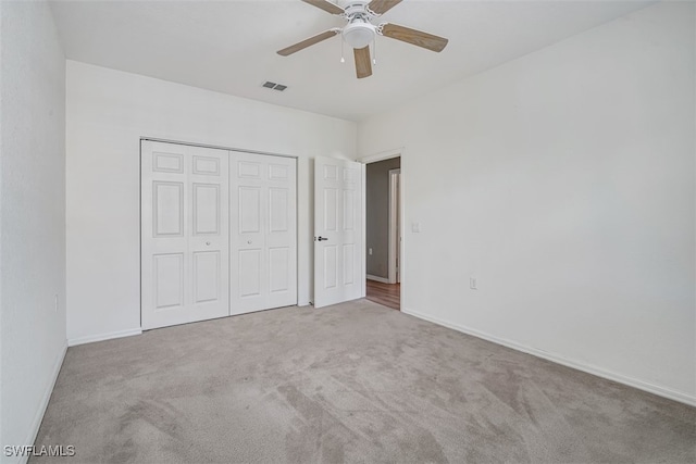 unfurnished bedroom with ceiling fan, a closet, and light colored carpet