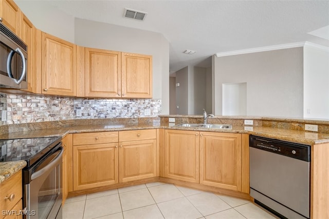 kitchen featuring light stone countertops, decorative backsplash, stainless steel appliances, and sink