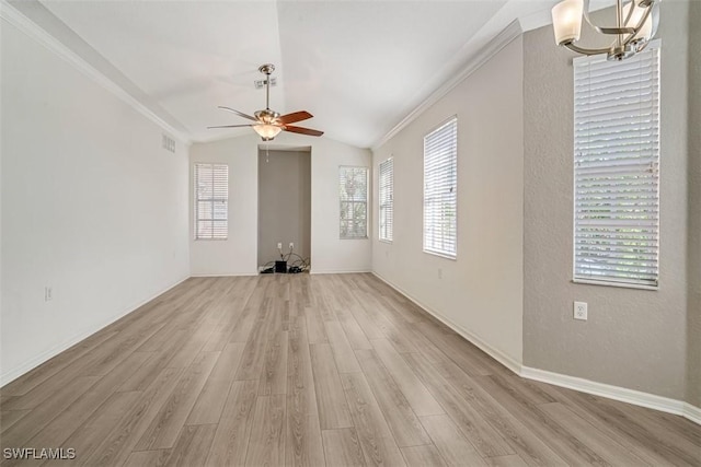 unfurnished living room with plenty of natural light, ornamental molding, light hardwood / wood-style flooring, and vaulted ceiling