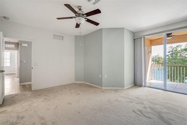 carpeted spare room featuring ceiling fan and a healthy amount of sunlight