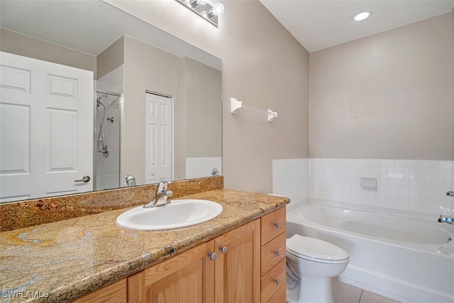 bathroom featuring tile patterned floors, a tub, vanity, and toilet