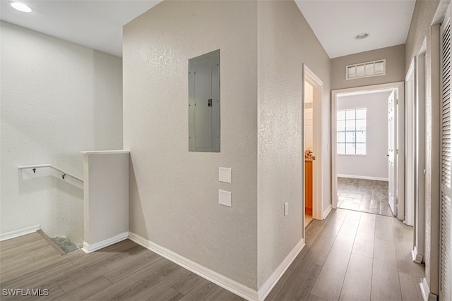 hallway with hardwood / wood-style floors and electric panel