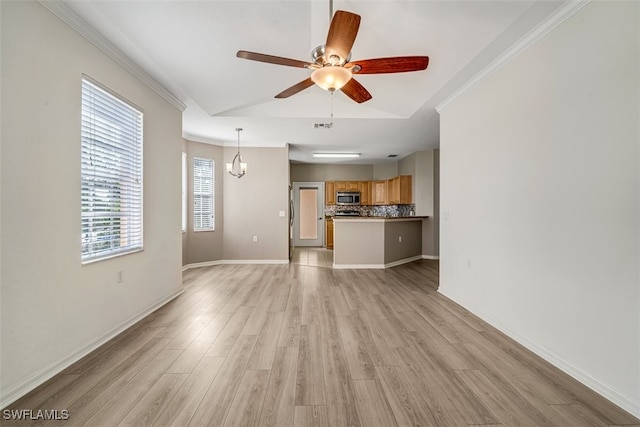 unfurnished living room with ornamental molding, ceiling fan with notable chandelier, light hardwood / wood-style floors, and lofted ceiling