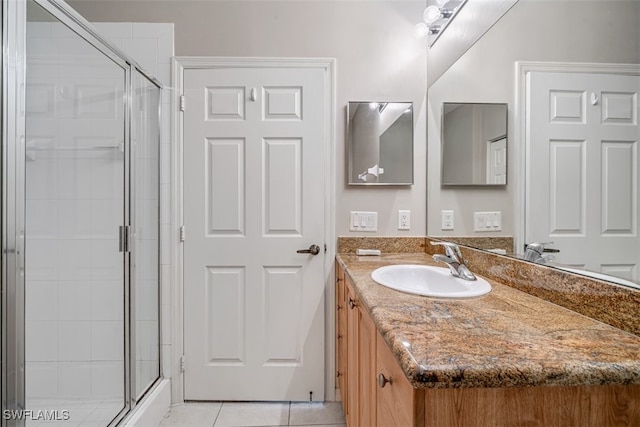 bathroom featuring tile patterned floors, vanity, and a shower with shower door