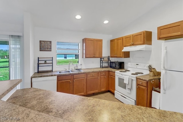 kitchen featuring white appliances, sink, light tile patterned floors, and a healthy amount of sunlight