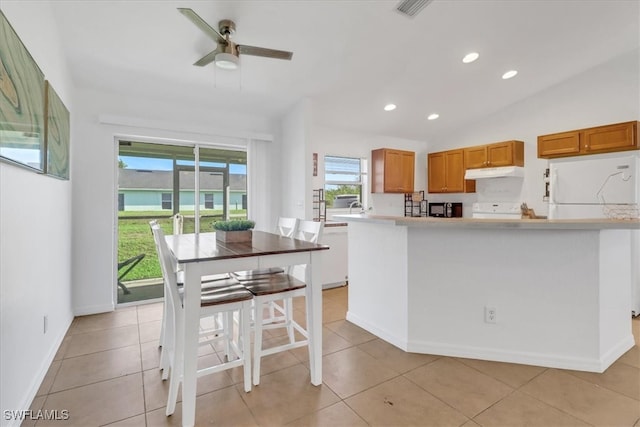 kitchen featuring lofted ceiling, light tile patterned floors, ceiling fan, and white appliances