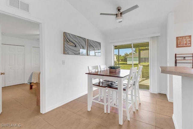 tiled dining room featuring ceiling fan and vaulted ceiling