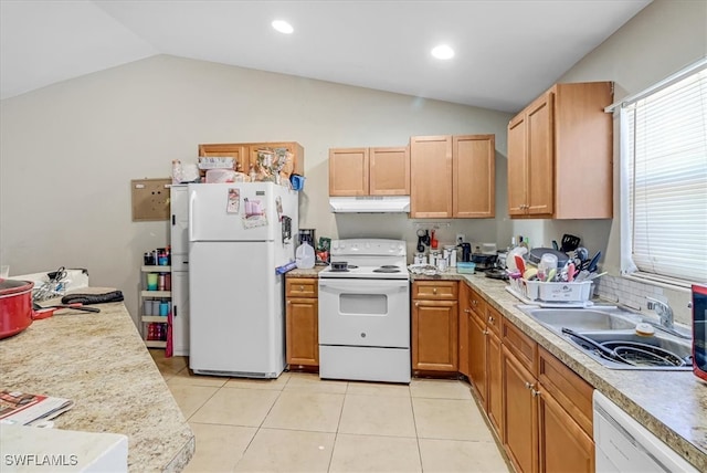 kitchen with sink, white appliances, vaulted ceiling, and light tile patterned flooring