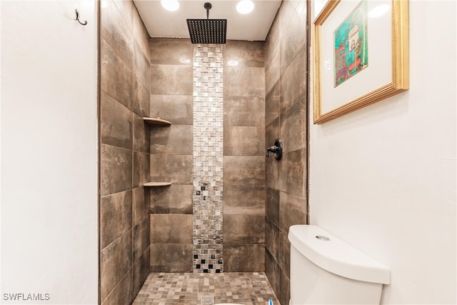 bathroom with toilet and a tile shower