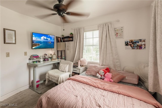 bedroom with ceiling fan, wood finished floors, and baseboards