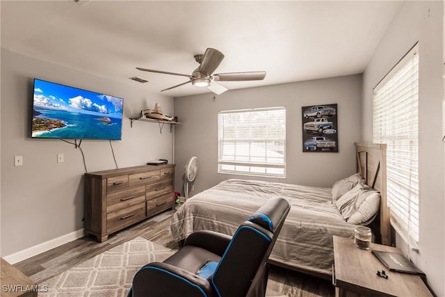 bedroom with visible vents, ceiling fan, baseboards, and wood finished floors