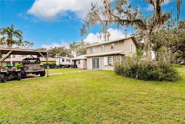 back of property featuring a lawn and a carport