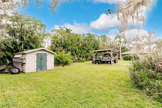 view of yard featuring an outbuilding, a carport, and a shed