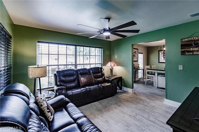 living room with visible vents, baseboards, ceiling fan, and wood finished floors
