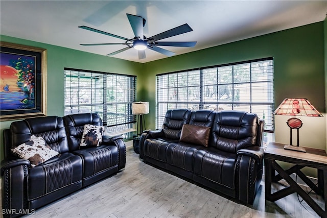 living room with light wood-type flooring, a wealth of natural light, and ceiling fan