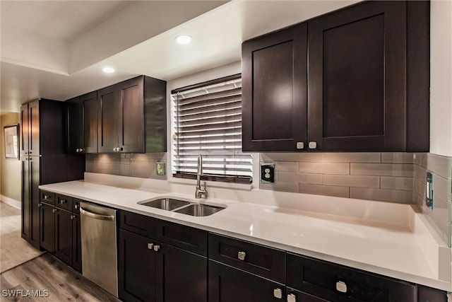 kitchen with dark brown cabinetry, decorative backsplash, sink, stainless steel dishwasher, and light hardwood / wood-style flooring