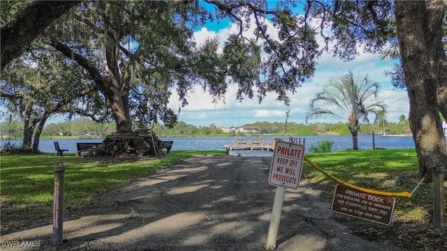 view of property's community featuring a lawn and a water view