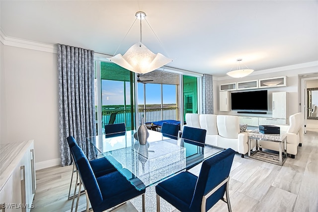 dining space with light wood-type flooring, floor to ceiling windows, and crown molding