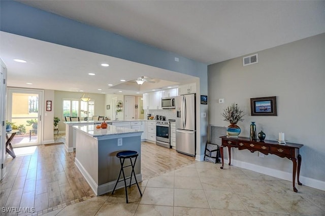 5103 Sunnybrook Ct Unit 3, Cape Coral, FL 33904 - kitchen with appliances with stainless steel finishes, a peninsula, white cabinetry, light countertops, and baseboards