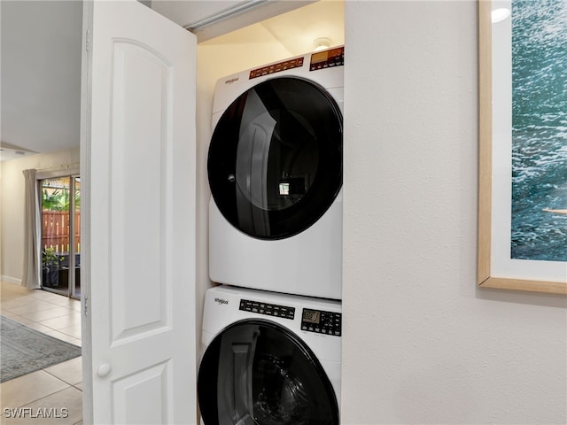 laundry room with light tile patterned floors and stacked washer and clothes dryer