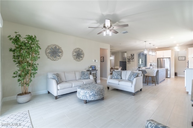 living room featuring ceiling fan with notable chandelier