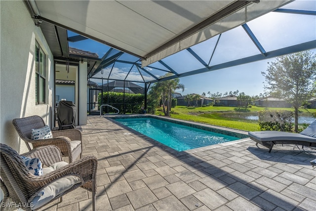 view of pool with a patio area, a water view, and glass enclosure