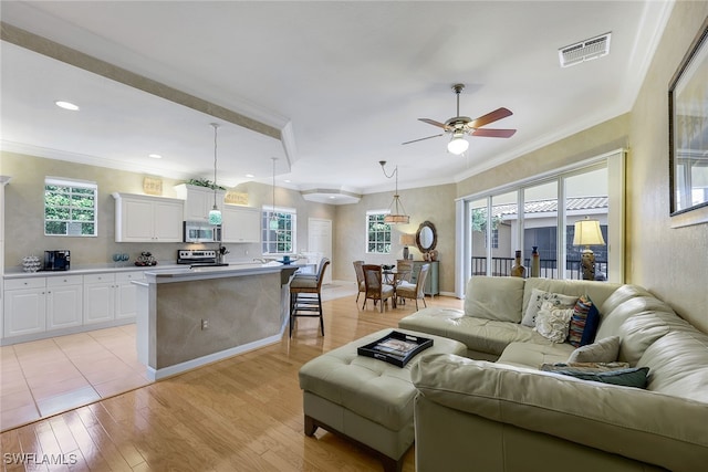 living room with light hardwood / wood-style flooring, plenty of natural light, and ceiling fan