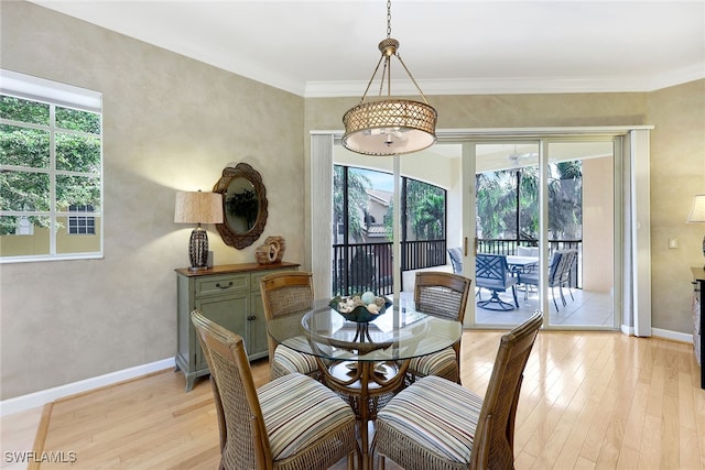 dining area with light hardwood / wood-style flooring, a wealth of natural light, and crown molding