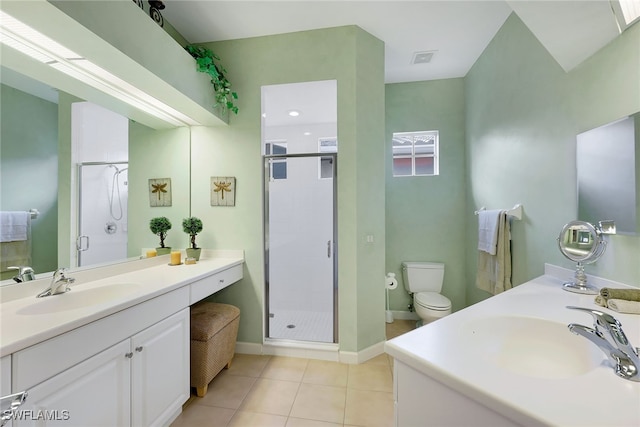 bathroom with tile patterned flooring, vanity, toilet, and a shower with shower door