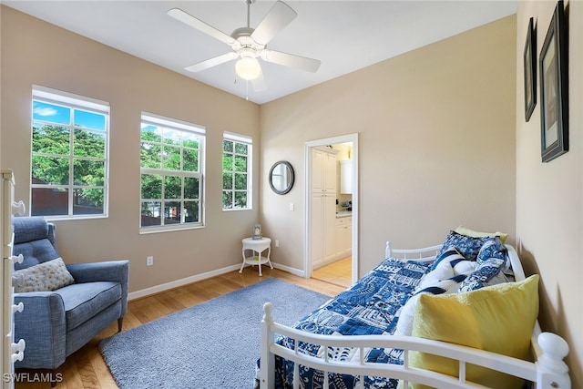 bedroom with light wood-type flooring, ensuite bath, and ceiling fan