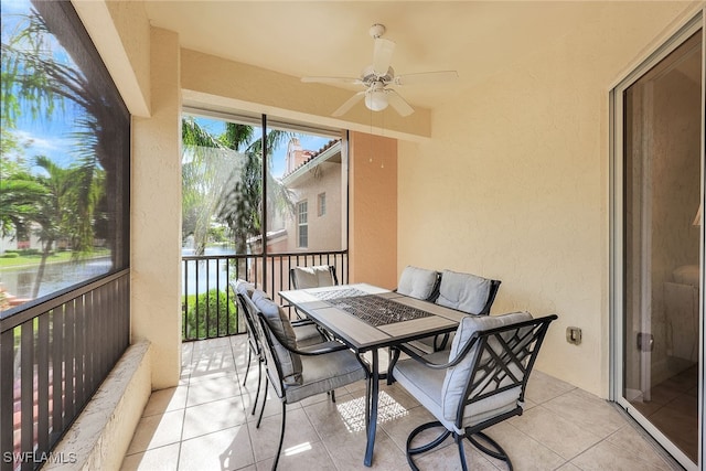 balcony with ceiling fan and a water view