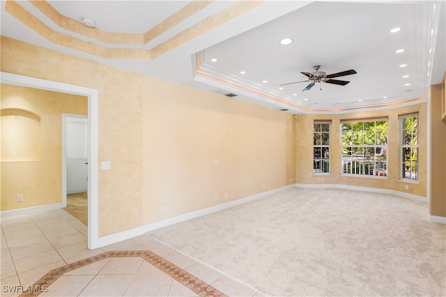 unfurnished room with light carpet, a tray ceiling, ceiling fan, and ornamental molding