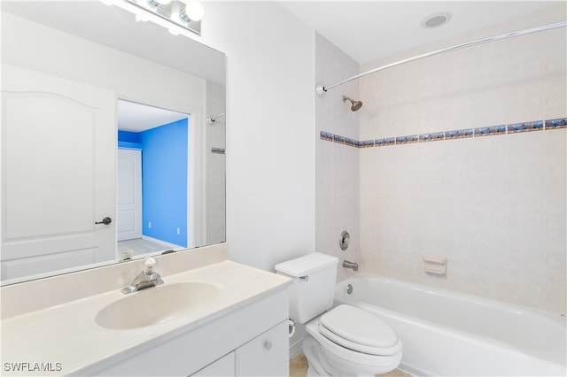 full bathroom featuring vanity, tiled shower / bath combo, and toilet