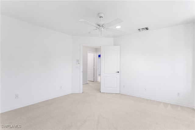 empty room with ceiling fan and light carpet