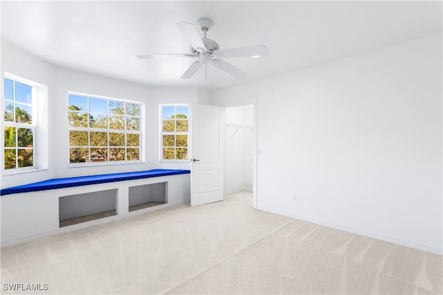 unfurnished room featuring light carpet and ceiling fan