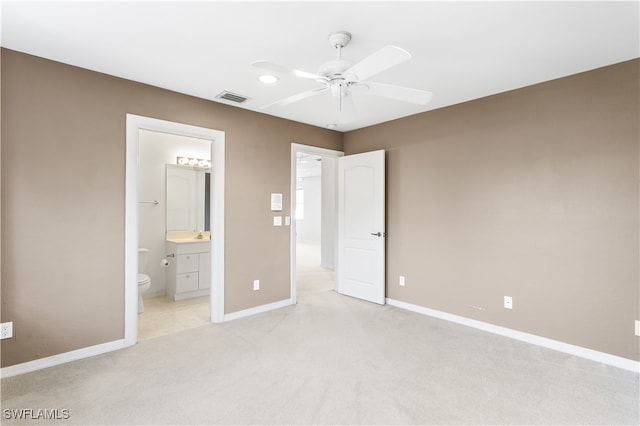 unfurnished bedroom with light carpet, ensuite bathroom, and ceiling fan