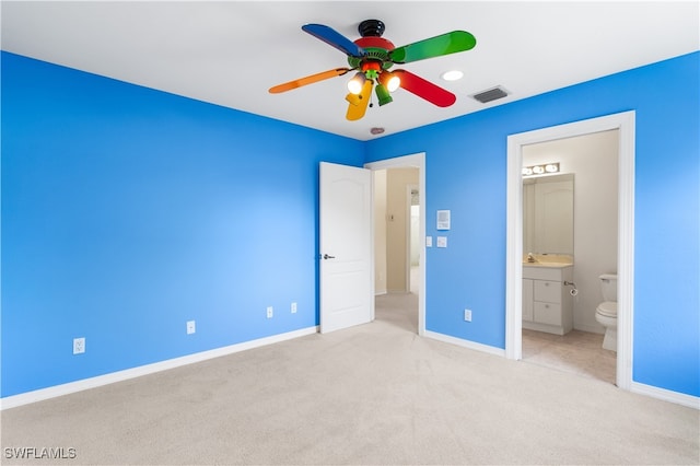 unfurnished bedroom featuring light carpet, connected bathroom, and ceiling fan