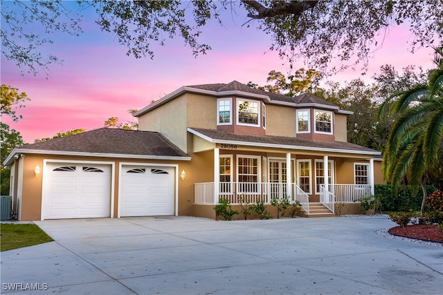 view of front of house featuring a porch, a garage, and cooling unit