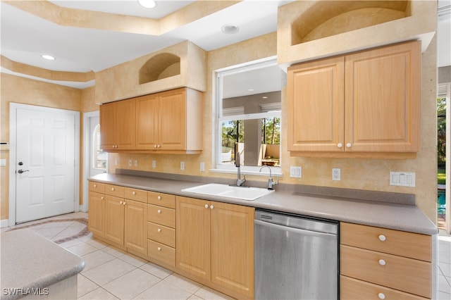 kitchen with a raised ceiling, dishwasher, light brown cabinets, and sink