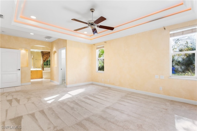 carpeted spare room featuring ceiling fan, a raised ceiling, and crown molding