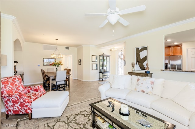 tiled living room with ceiling fan with notable chandelier and crown molding