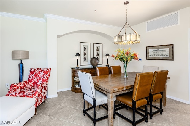 dining room with crown molding, light tile patterned floors, and an inviting chandelier