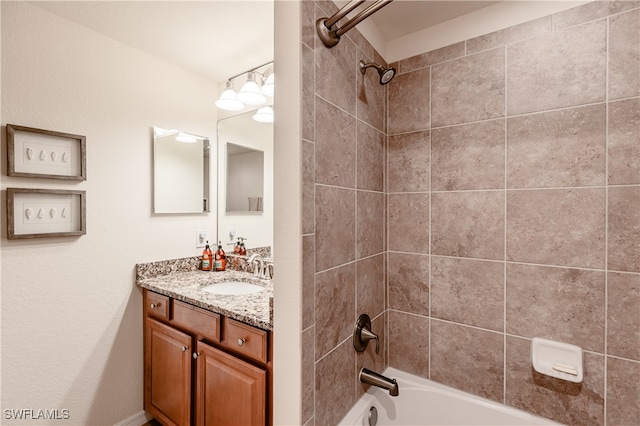 bathroom featuring vanity and tiled shower / bath