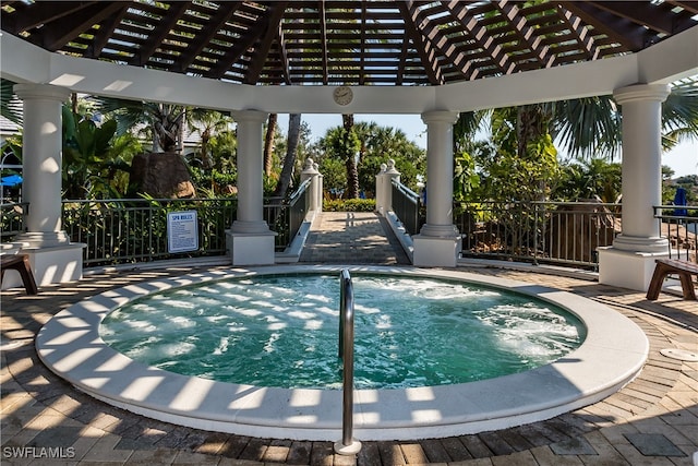 view of pool with a gazebo and an in ground hot tub