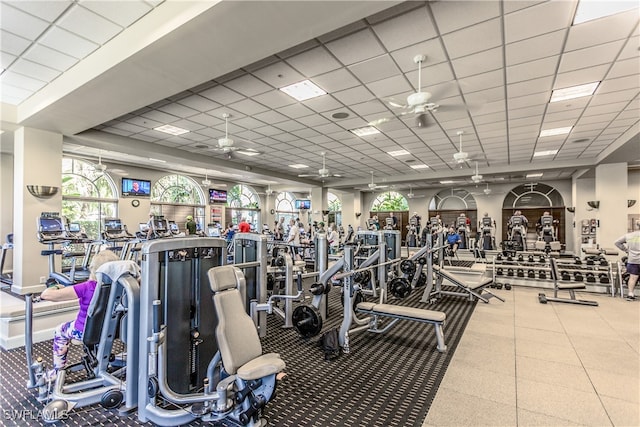 exercise room with a paneled ceiling and ceiling fan