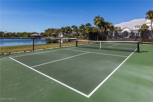 view of tennis court featuring a water view