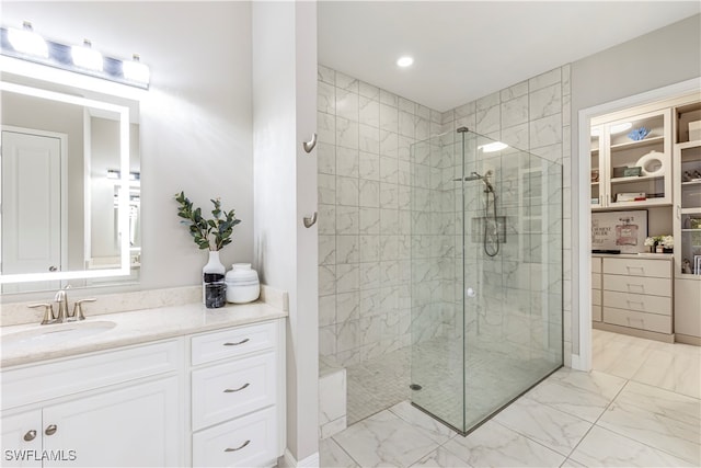 bathroom featuring a tile shower and vanity