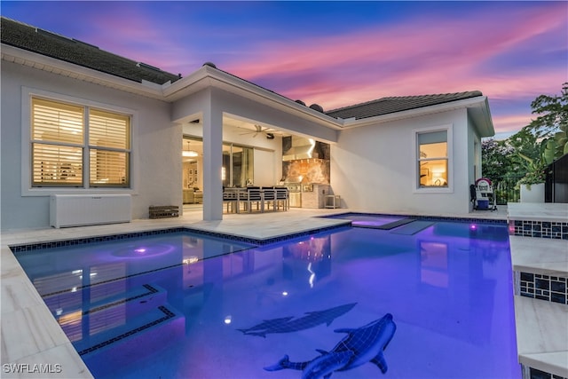 pool at dusk with an in ground hot tub, a patio, area for grilling, and ceiling fan