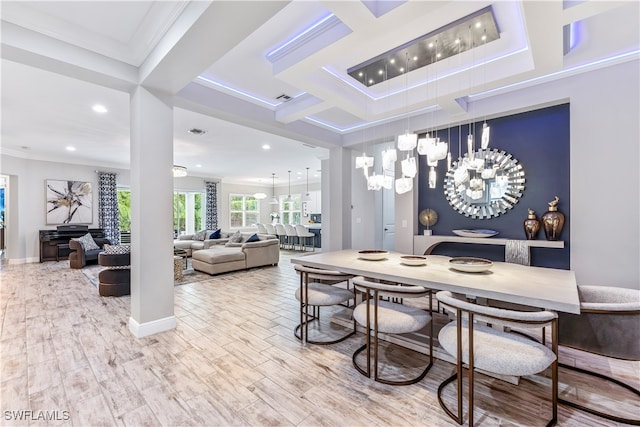 dining space with crown molding, a chandelier, coffered ceiling, and light wood-type flooring